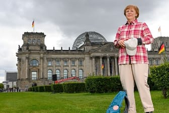 Die Wachsfigur von Bundeskanzlerin Angela Merkel (CDU) vor dem Reichstagsgebäude in Berlin.