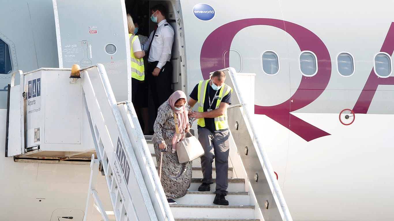 Ein Flughafenmitarbeiter hilft einer geflüchteten Frau aus Afghanistan aus dem Flugzeug: Die EU will 100 Millionen Euro zusätzliche Hilfe geben.