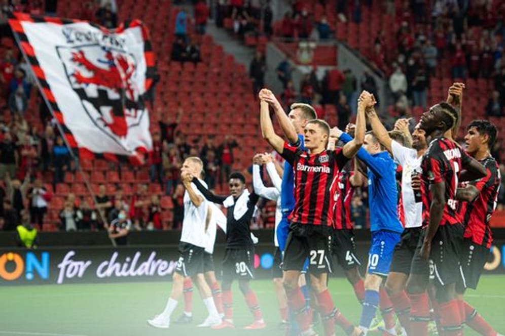 Die Leverkusener Spieler jubeln nach der Partie mit den Fans.