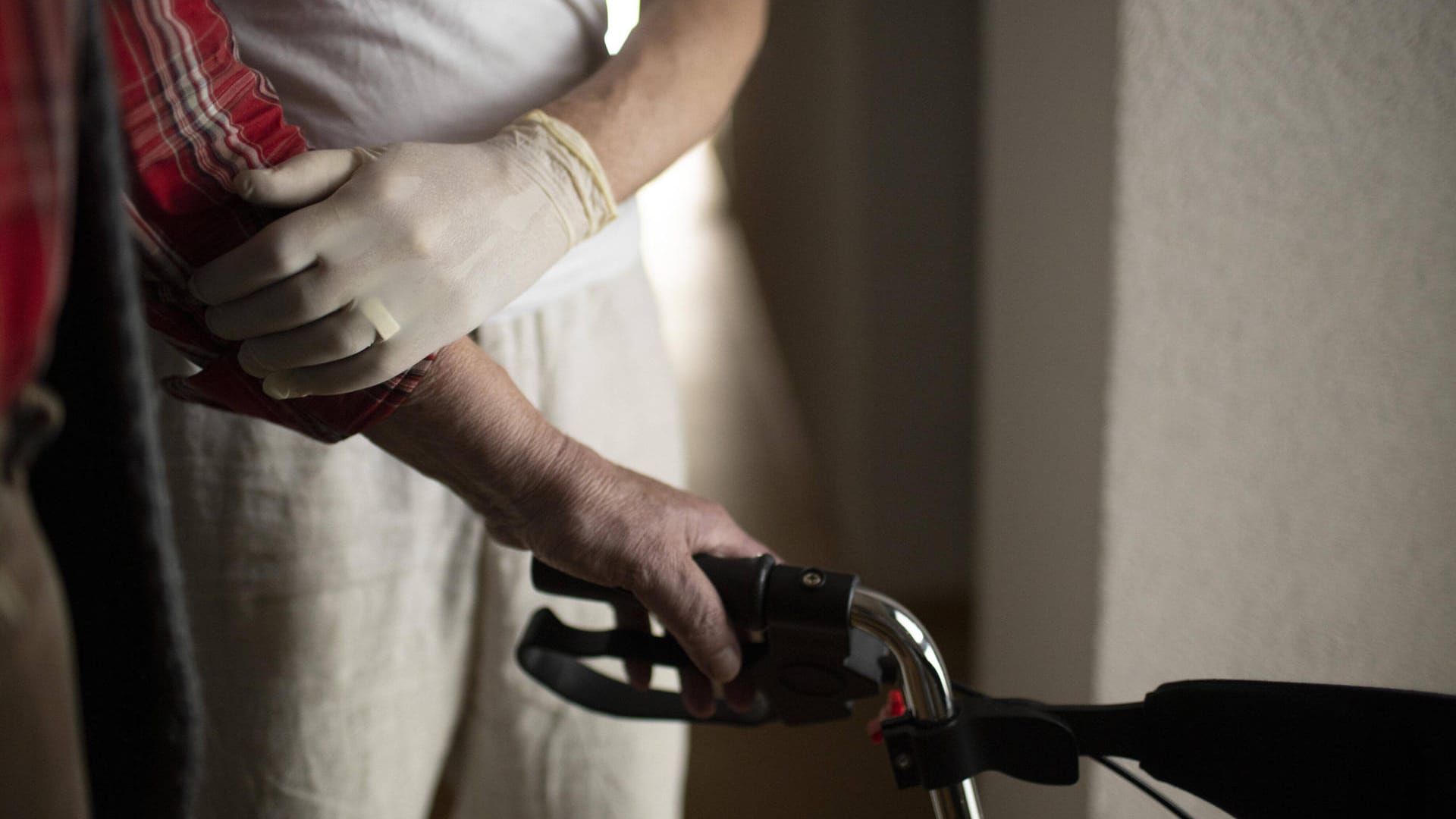 Ein Pfleger stützt einen alten Mann am Rollator (Symbolbild): In Leverkusen sollen zwei Pfleger ihren Patienten ohne Not zu viele Medikamente gegeben haben.