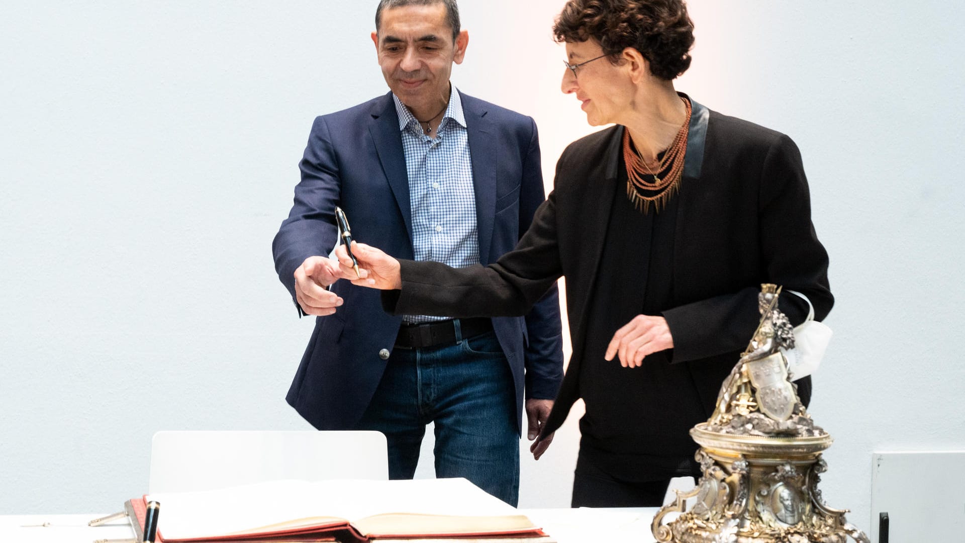 Ugur Sahin (l) und Özlem Türeci tragen sich in das Goldene Buch ein. Köln ehrt Biontech-Gründer im Rathaus. Die beiden Forscher werden von der Stadt Köln geehrt.