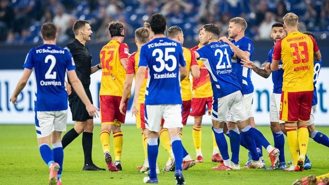 Zahlreiche Spieler diskutieren nach einer roten Karte für Schalkes Victor Palsson mit Schiedsrichter Christof Günsch (2. Zahlreiche Spieler diskutieren nach einer roten Karte für Schalkes Victor Palsson mit Schiedsrichter Christof Günsch (2.