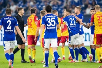 Zahlreiche Spieler diskutieren nach einer roten Karte für Schalkes Victor Palsson mit Schiedsrichter Christof Günsch (2.