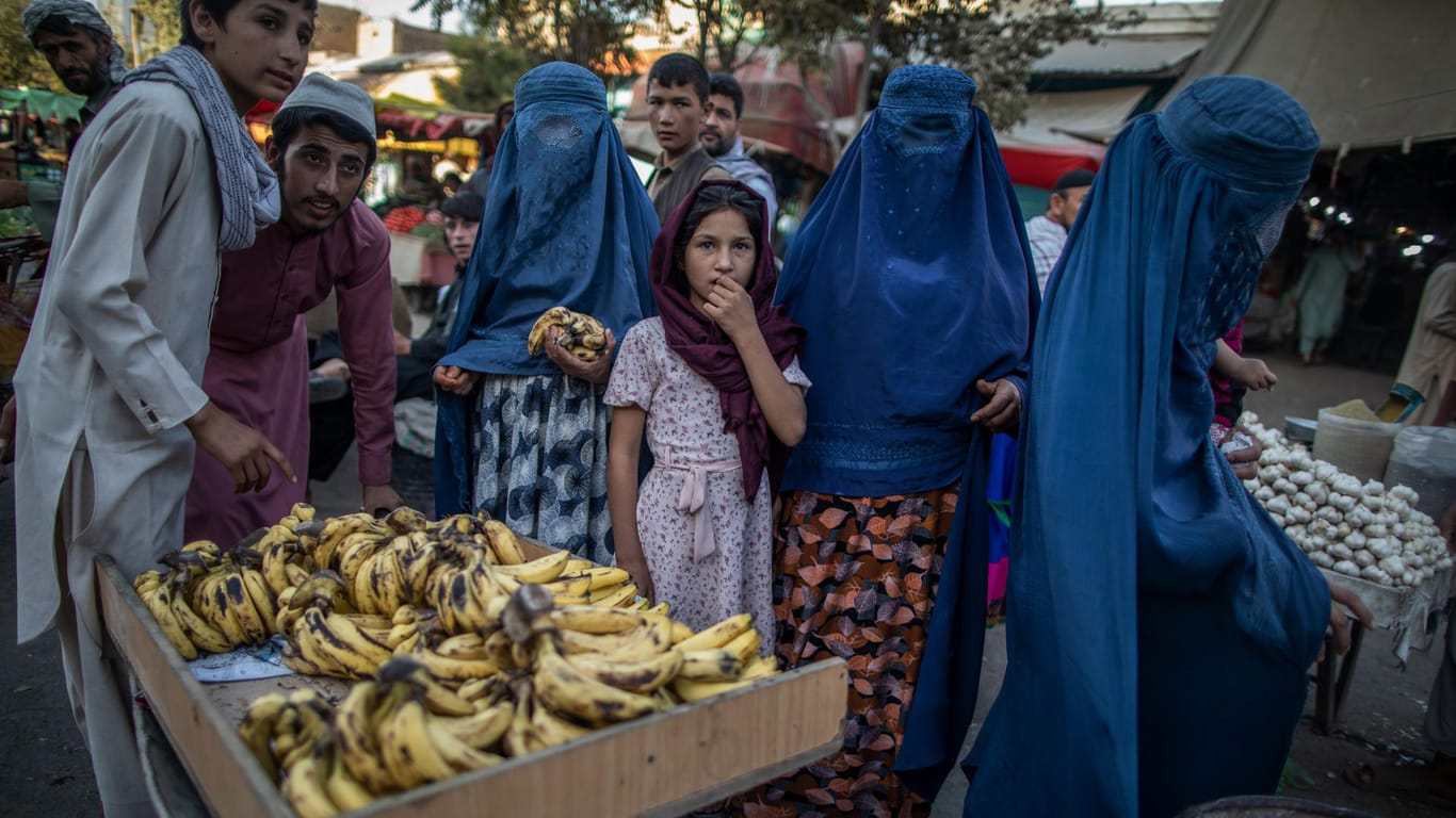 Afghanische Frauen stehen auf einem Markt vor einem Bananenstand: Frauen wurden aufgefordert, sich von ihrem Arbeitsplatz fernzuhalten.