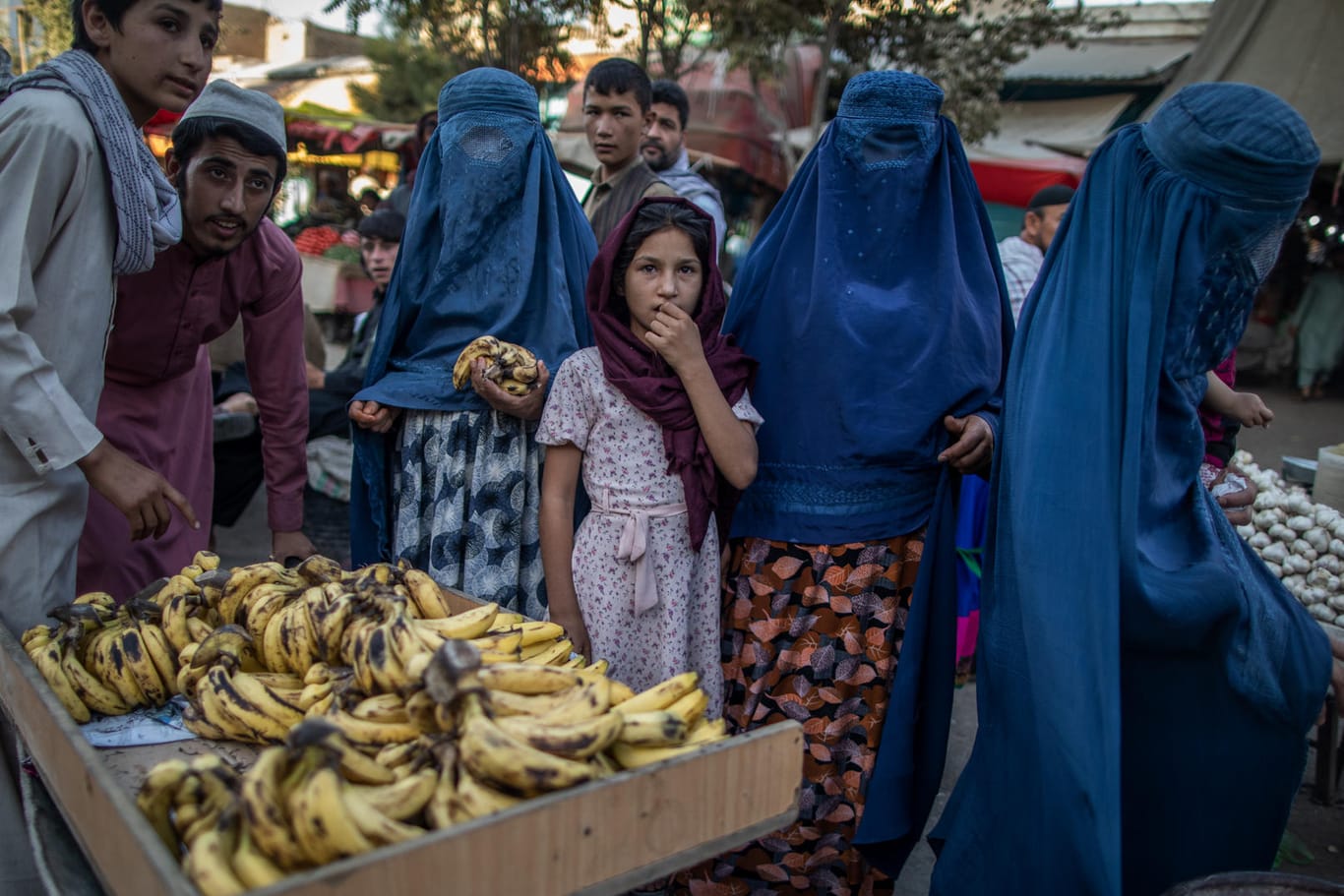 Afghanische Frauen stehen auf einem Markt vor einem Bananenstand: Frauen wurden aufgefordert, sich von ihrem Arbeitsplatz fernzuhalten.