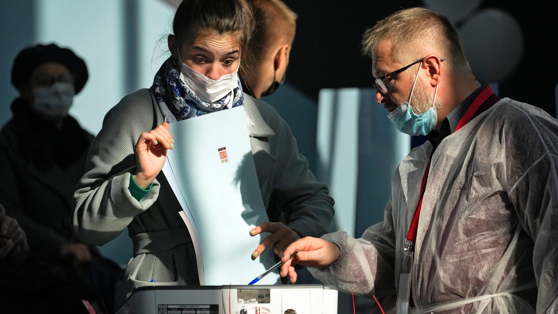 In einem Wahllokal in St. Petersburg hilft ein Mitglied einer Wahlkommission einer Frau bei der Stimmabgabe: Die Abstimmung gilt als ein wichtiger Stimmungstest für Präsident Wladimir Putin.