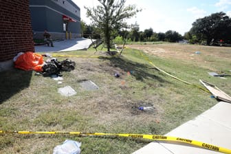 Ein Fallschirm und andere Gegenstände liegen vor einem Ole Donut, in dem ein Pilot gelandet ist: Ein Flieger ist über einem Wohngebiet abgestürzt.