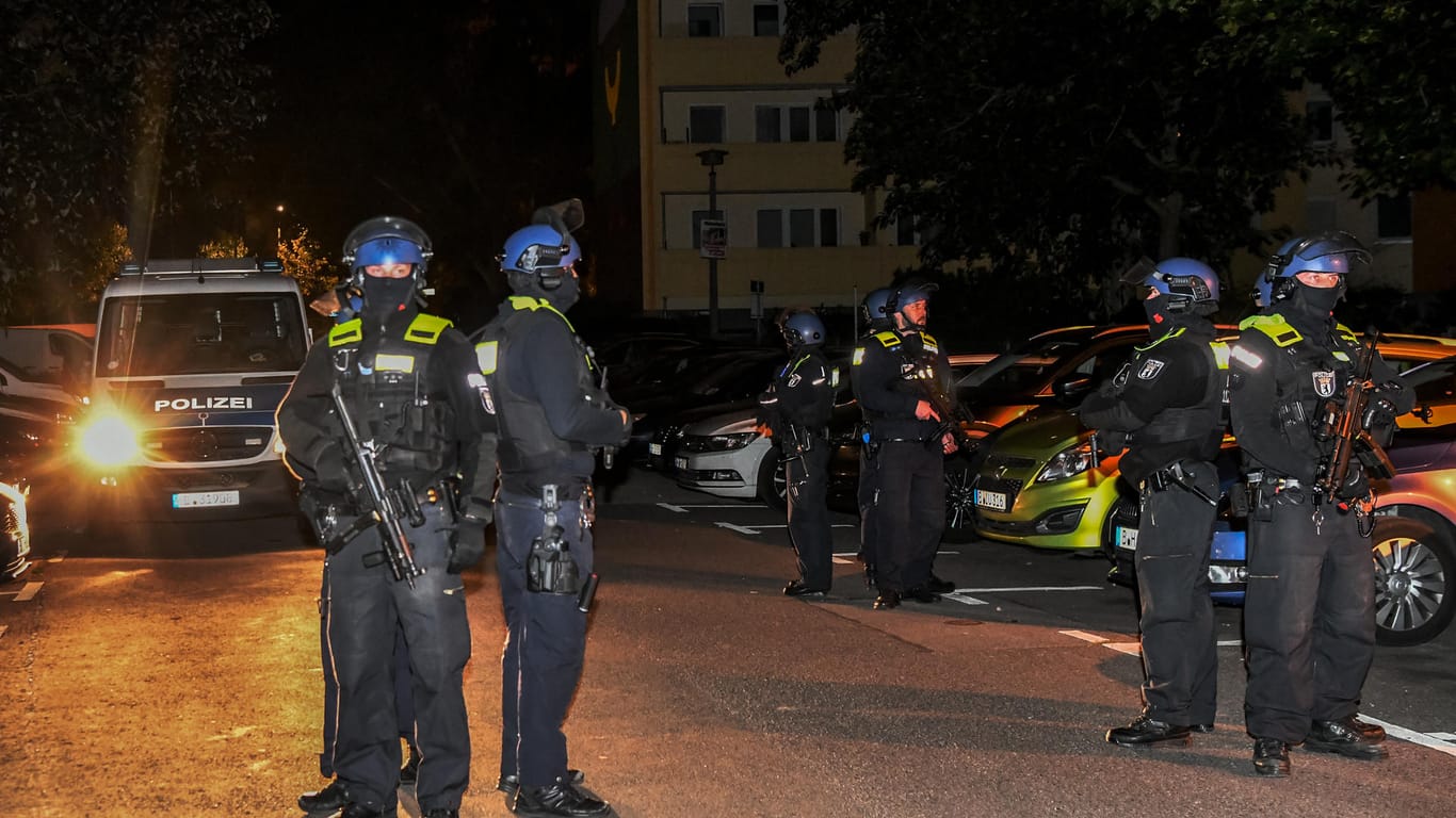 Polizisten mit Maschinenpistolen sichern sich gegenseitig auf der Kölpitzer Straße: Dort wurde vor einem Haus ein Mann mit Schussverletzungen gefunden.