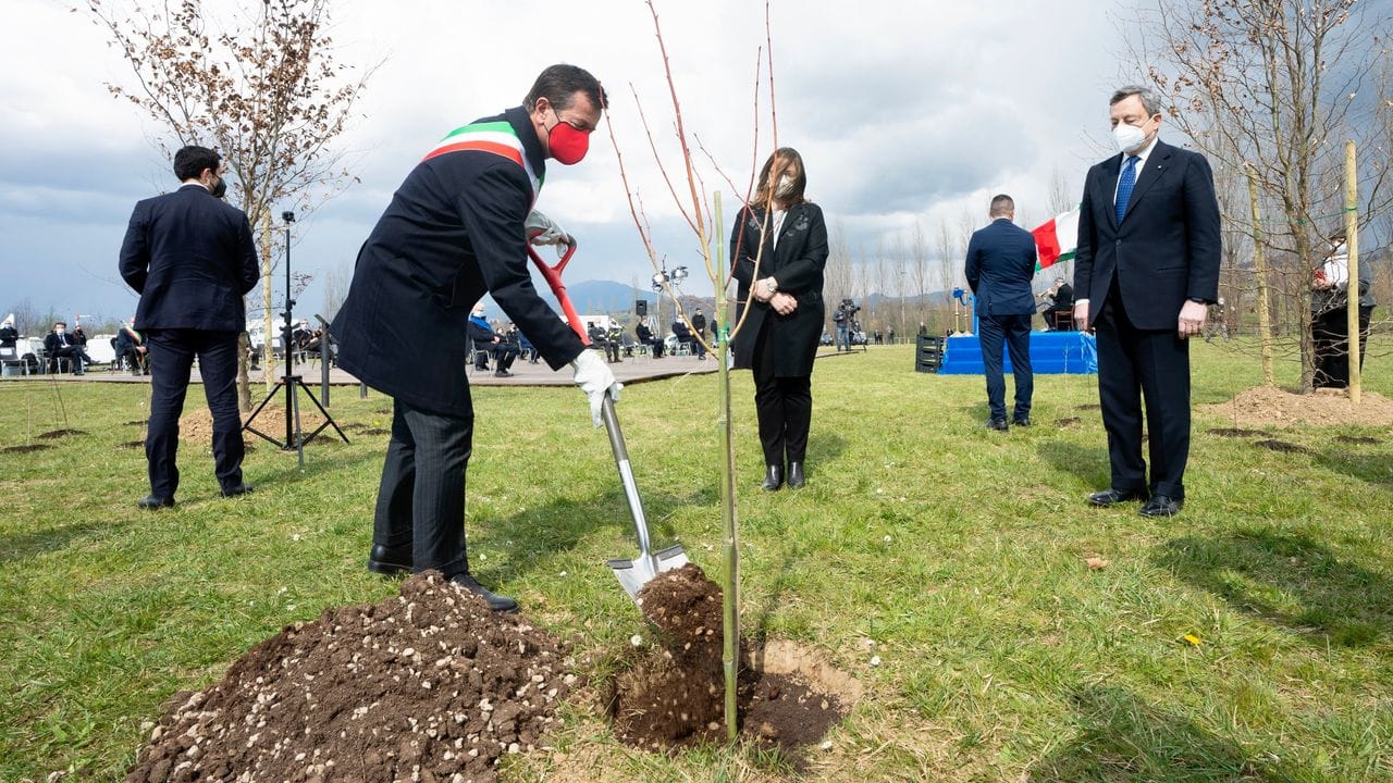 Mario Draghi (r), Premierminister von Italien, nimmt an den Feierlichkeiten zum nationalen Gedenktag für die Corona-Opfer teil, bei der Bäume für einen Gedenkwald gepflanzt werden.