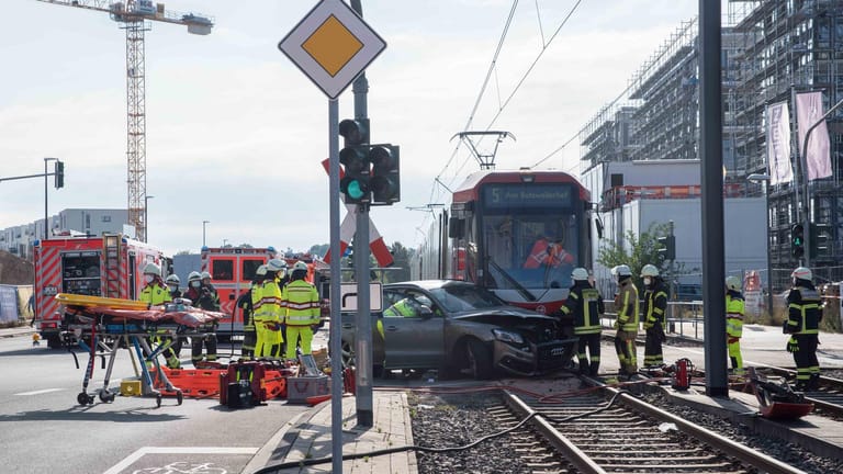 Das zerstörte Auto und die Straßenbahn an der Unfallstelle: Rettungskräfte konnten die verletzte Fahrerin befreien und ins Krankenhaus transportieren.