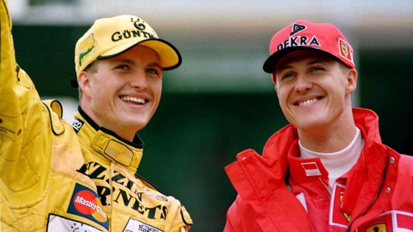Die Brüder Michael Schumacher (r, Ferrari) und Ralf Schumacher (Jordan) winken nach dem Großen Preis von Deutschland auf dem Hockenheimring den Zuschauern zu.