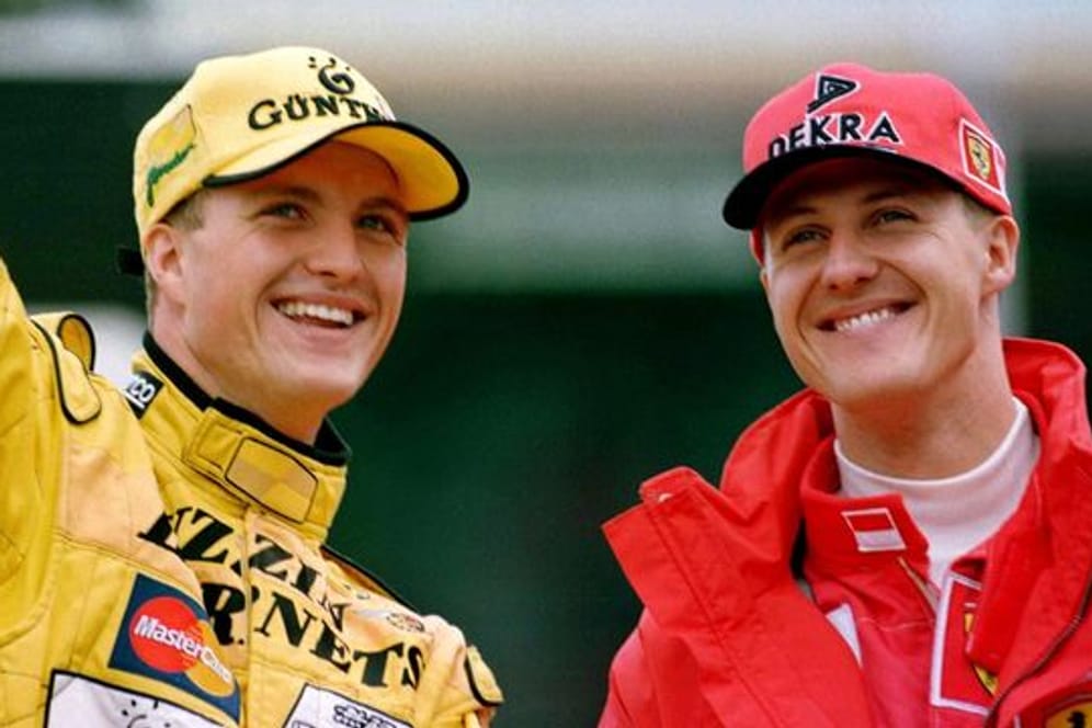 Die Brüder Michael Schumacher (r, Ferrari) und Ralf Schumacher (Jordan) winken nach dem Großen Preis von Deutschland auf dem Hockenheimring den Zuschauern zu.