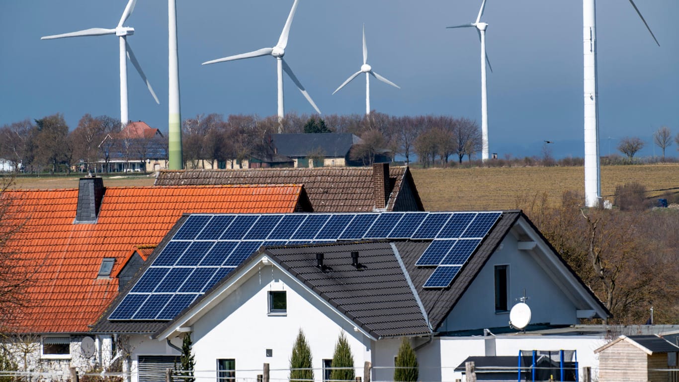 Windkraftanlagen und Wohnhäuser mit Solaranlagen (Symbolbild): Viele Parteien wollen erneuerbare Energien ausbauen.