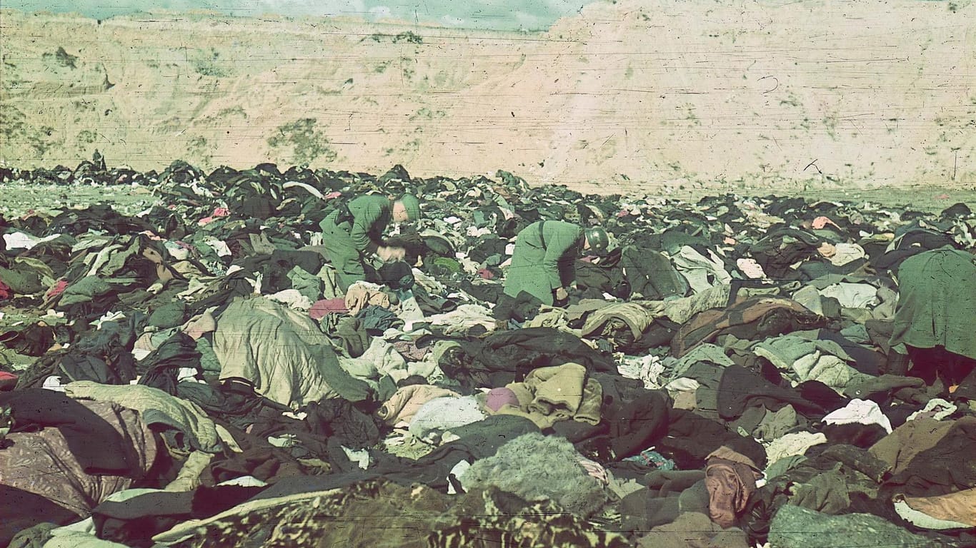 Deutsche Schützen durchsuchen nach dem Massaker in der Schlucht Babi Jar bei Kiew Kleiderberge der ermordeten Juden. Das Bild machte der Fotograf Johannes Hähle, Mitglied einer deutschen Propagandakompanie.
