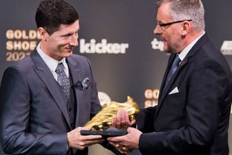 Jörg Jakob (r), Kicker-Chefredakteur, übergibt den Goldenen Schuh 2021 an Fußballprofi Robert Lewandowski.
