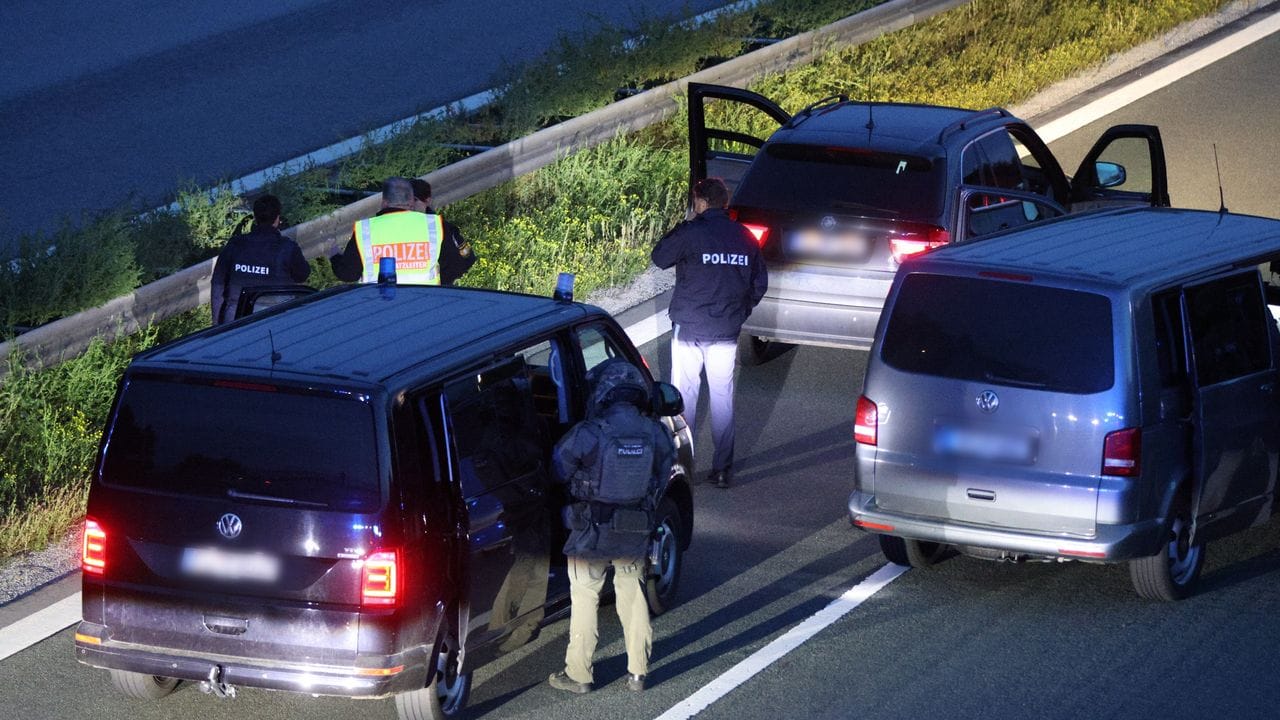 Polizisten stehen mit ihren Fahrzeugen auf der Autobahn 9.