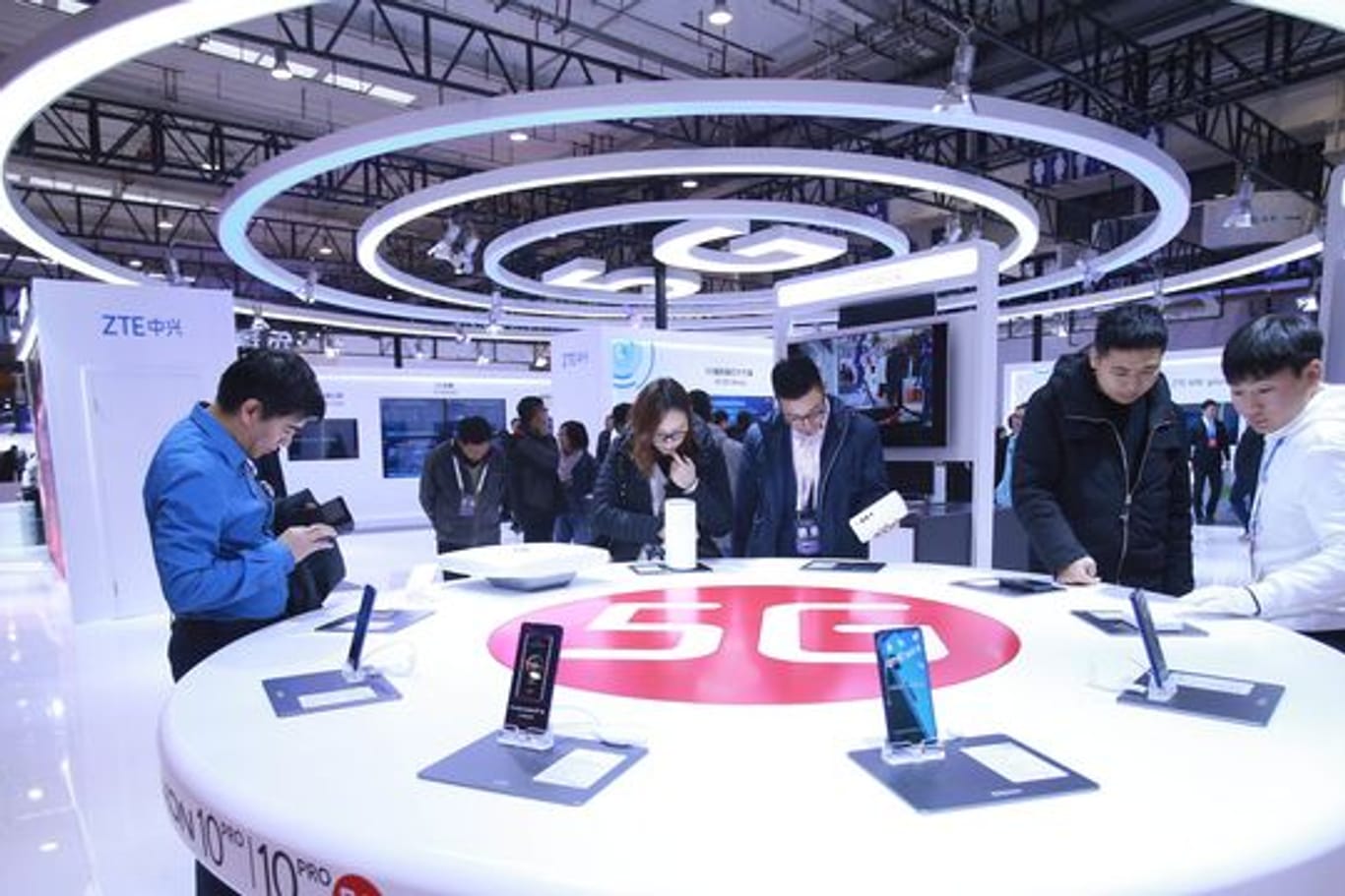 Messe-Besucher schauen in Peking neue Smartphones mit 5G-Technologie an (Archivbild).