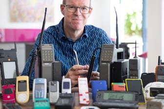 Auf dem vom Mobile Phone Museum herausgegebenen Foto sitzt Ben Wood, Gründer des Museums und Analyst des Unternehmens CCS Insight, hinter einigen der über 2.