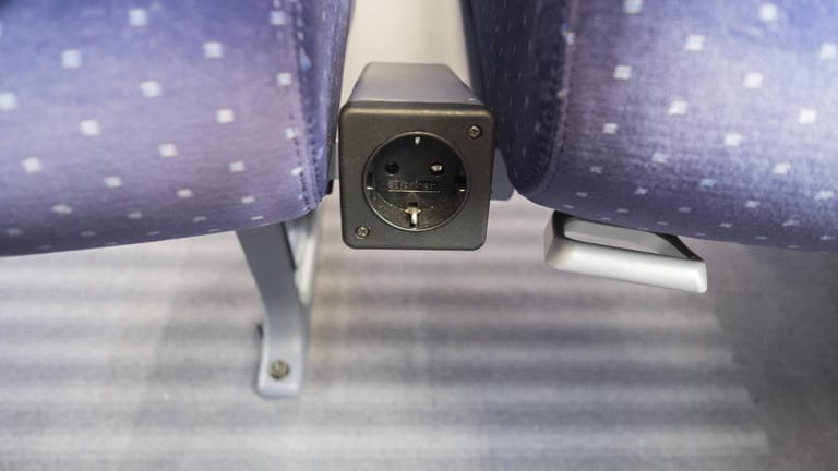 Eine Steckdose zwischen zwei Bahn-Sitzen (Symbolbild): Ein unbekannter Täter hat hier einen Stecker so manipuliert, dass alleine eine Berührung lebensgefährlich sein kann.