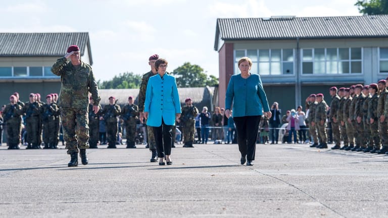 Kramp-Karrenbauer und Merkel gehen über den Appellplatz: Das Fallschirmjägerregiment 31 der Bundeswehr wird für den Einsatz beim Ausfliegen Schutzbedürftiger aus Kabul gewürdigt.