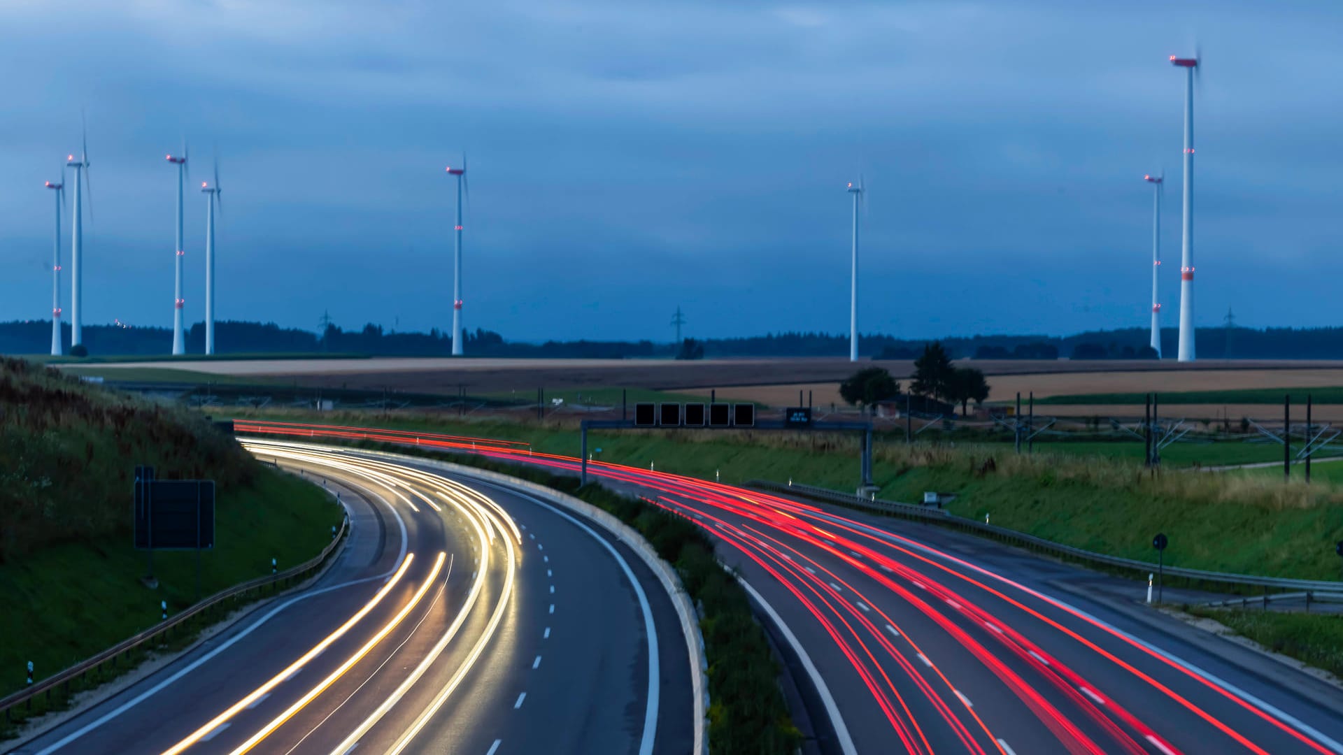 Lichtspuren von Autos vor einem Windpark in Baden-Württemberg: Die aus der Windkraft gewonnene Energie könnte in grünen Wasserstoff umgewandelt und so über längere Zeit genutzt werden (Symbolbild).