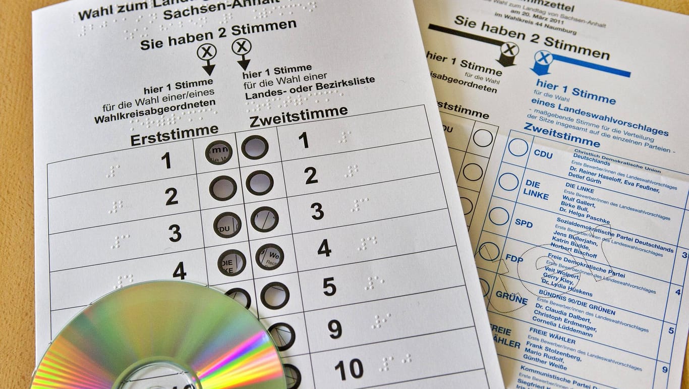 Eine Wahlscheinschablone, eine CD mit Informationen und ein Stimmzettel der Landtagswahl 2011 in Sachsen-Anhalt: Die Schablonen werden von Blindenvereinen verteilt (Symbolbild).
