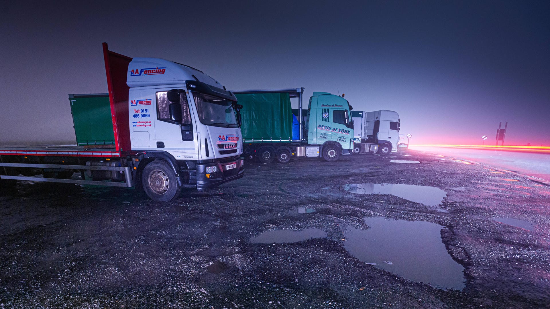 LKW parken nachts im britischen West Yorkshire (Symbolbild): Der akute Fahrermangel bedeutet in Großbritannien leere Regale.