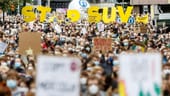 In Hamburg halten Aktivisten auf der Klima-Demo Buchstaben, die die Worte "STOP SUV" bilden, in die Höhe. Sie fordern sozial gerechte und effektive Maßnahmen, um den globalen Temperaturanstieg auf 1,5 Grad Celsius zu begrenzen.