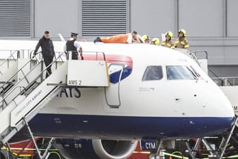 Skurrile Aktion: James Brown (in Orange) kletterte auf eine British-Airways-Maschine und klebte seine Hand an der Flugzeughülle fest.