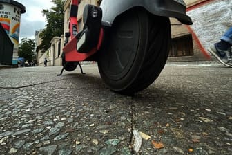 Ein E-Scooter steht mitten auf einem Gehweg in Neukölln