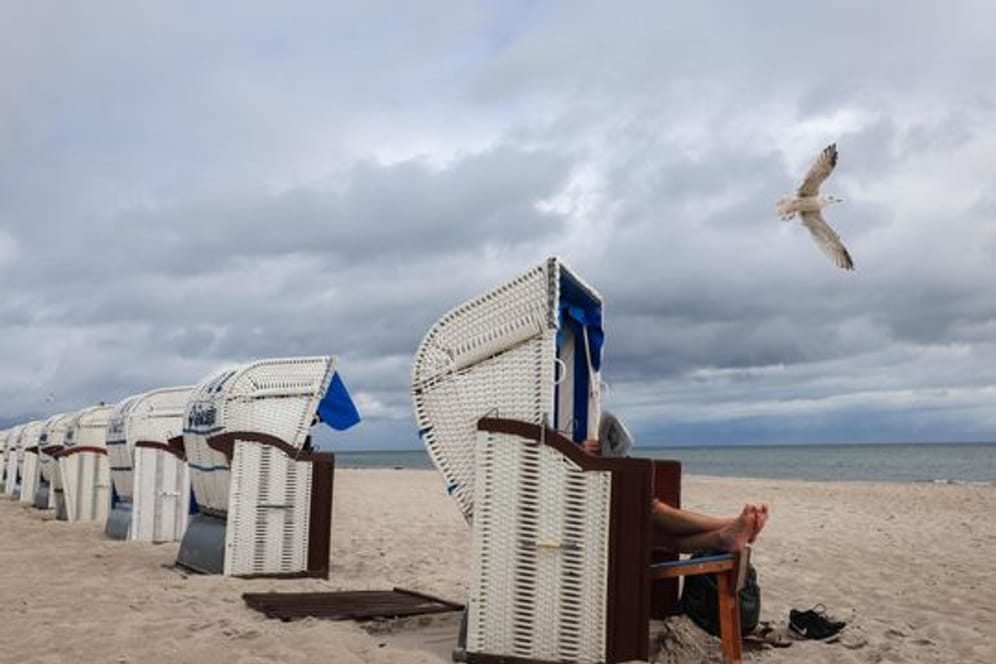 Ein Urlauber liest Zeitung in seinem Strandkorb an der Ostsee