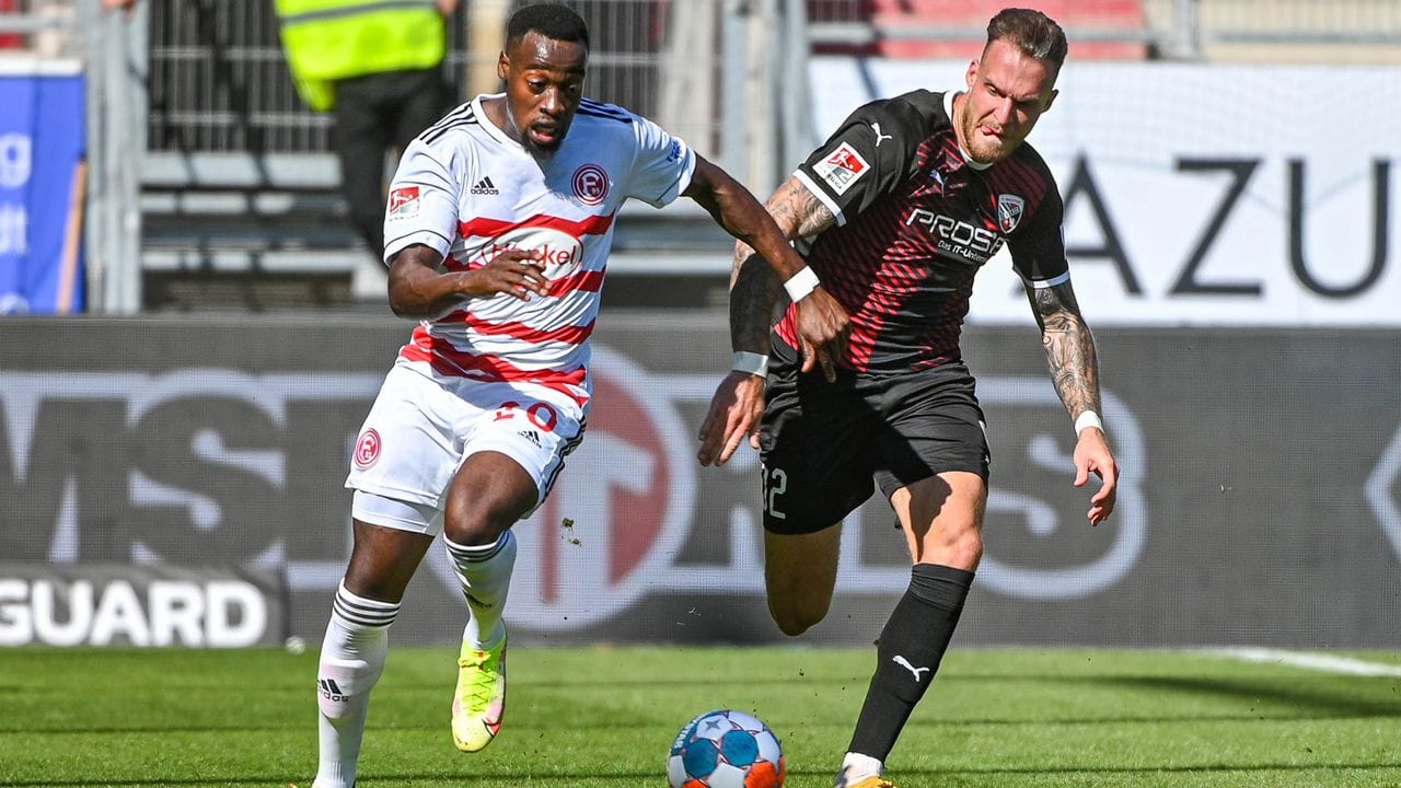 Khaled Narey von Düsseldorf (l) und Patrick Schmidt vom FC Ingolstadt jagen dem Ball hinterher.