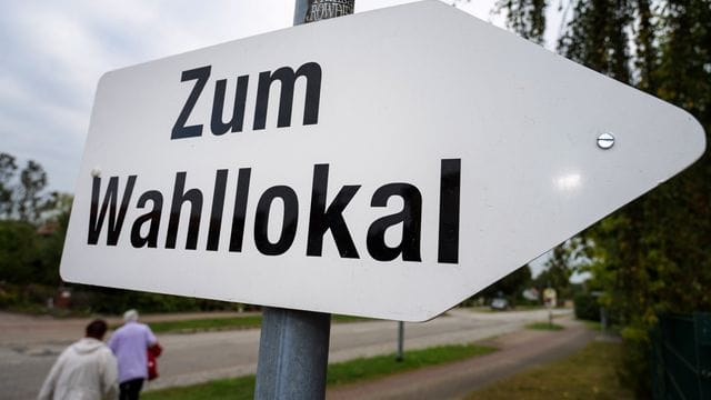 Ein Schild weist den Weg zu einem Wahllokal