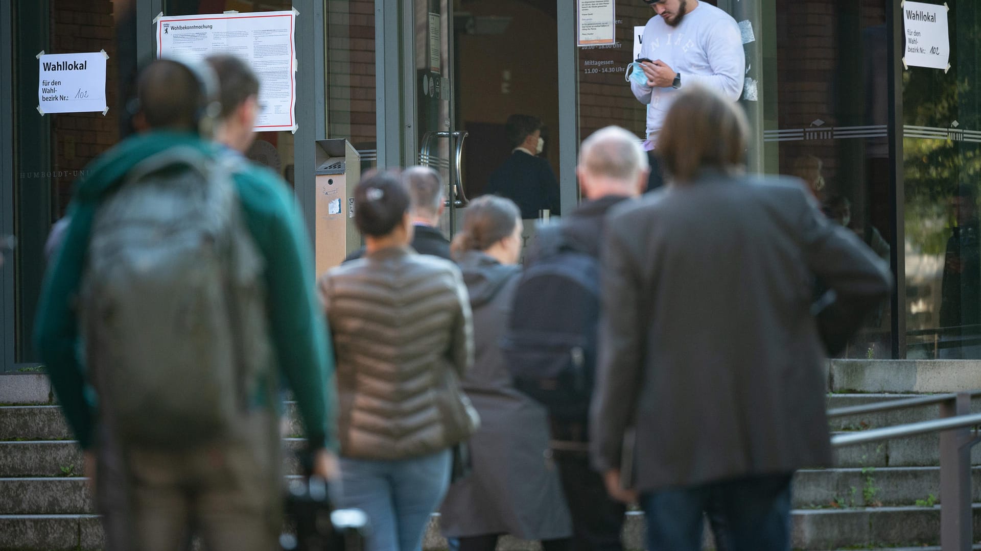 Wählerinnen und Wähler warten kurz vor 9 Uhr vor dem Wahllokal: Die Wahllokale 102 und 106 mussten aufgrund von technischen Schwierigkeiten rund eine Stunde später öffnen.