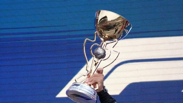 Weltmeister Lewis Hamilton mit der Siegertrophäe.