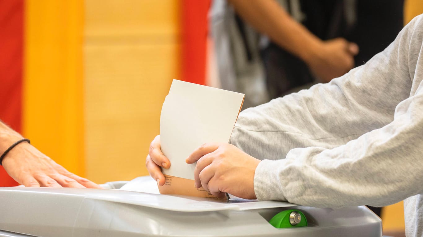 Eine Person wirft einen Wahlzettel in eine Wahlurne in Berlin (Symbolbild): In einem Wahllokal in Pankow mussten Wähler nach Hause geschickt werden.