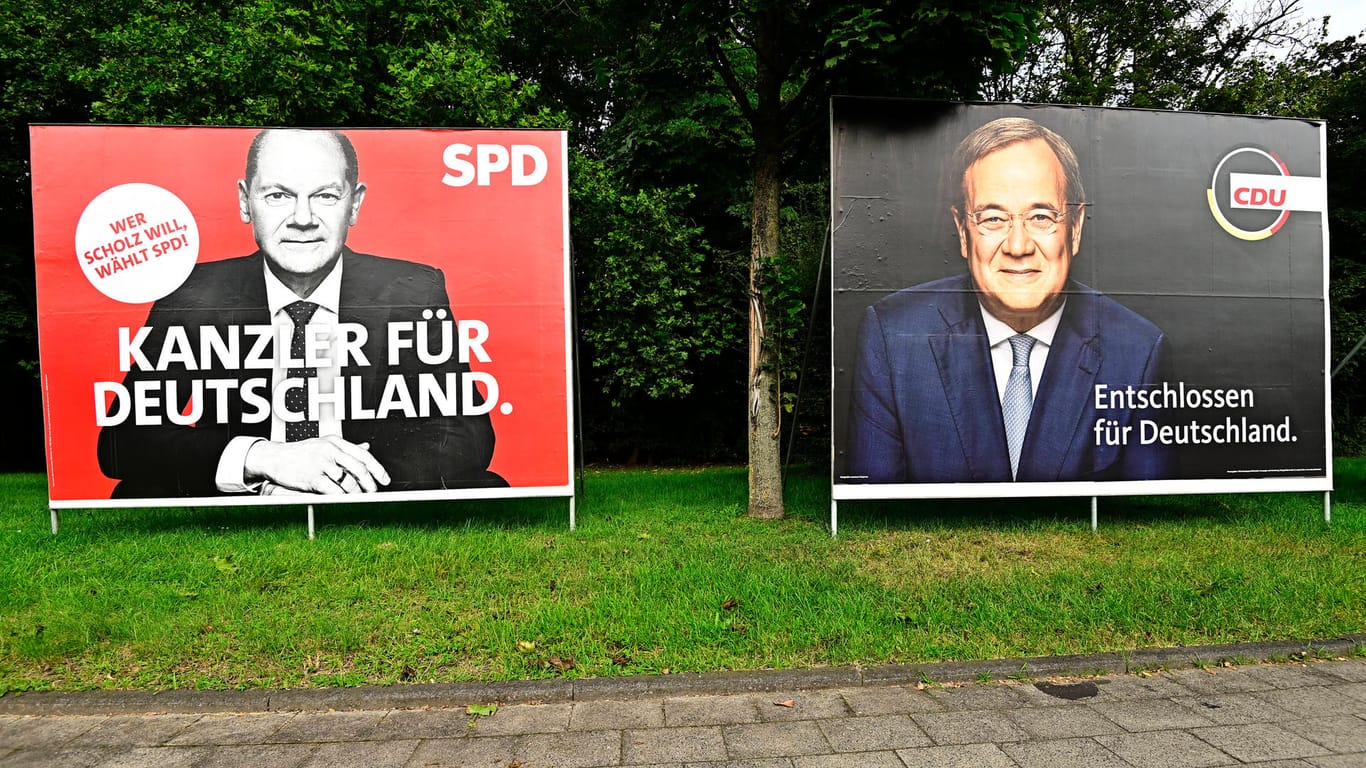 Wahlplakate für Olaf Scholz und Armin Laschet: Nach der Bundestagswahl gibt es mehrere Koalitionsmöglichkeiten; Ökonomen fürchten, dass lange Verhandlungen die Wirtschaft belasten könnten.