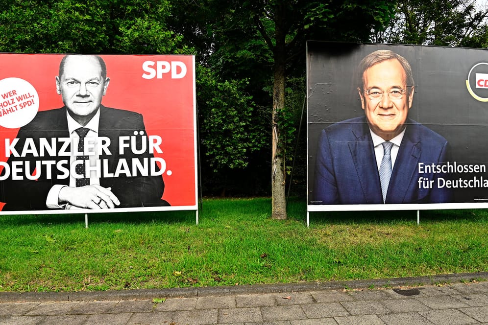 Wahlplakate für Olaf Scholz und Armin Laschet: Nach der Bundestagswahl gibt es mehrere Koalitionsmöglichkeiten; Ökonomen fürchten, dass lange Verhandlungen die Wirtschaft belasten könnten.