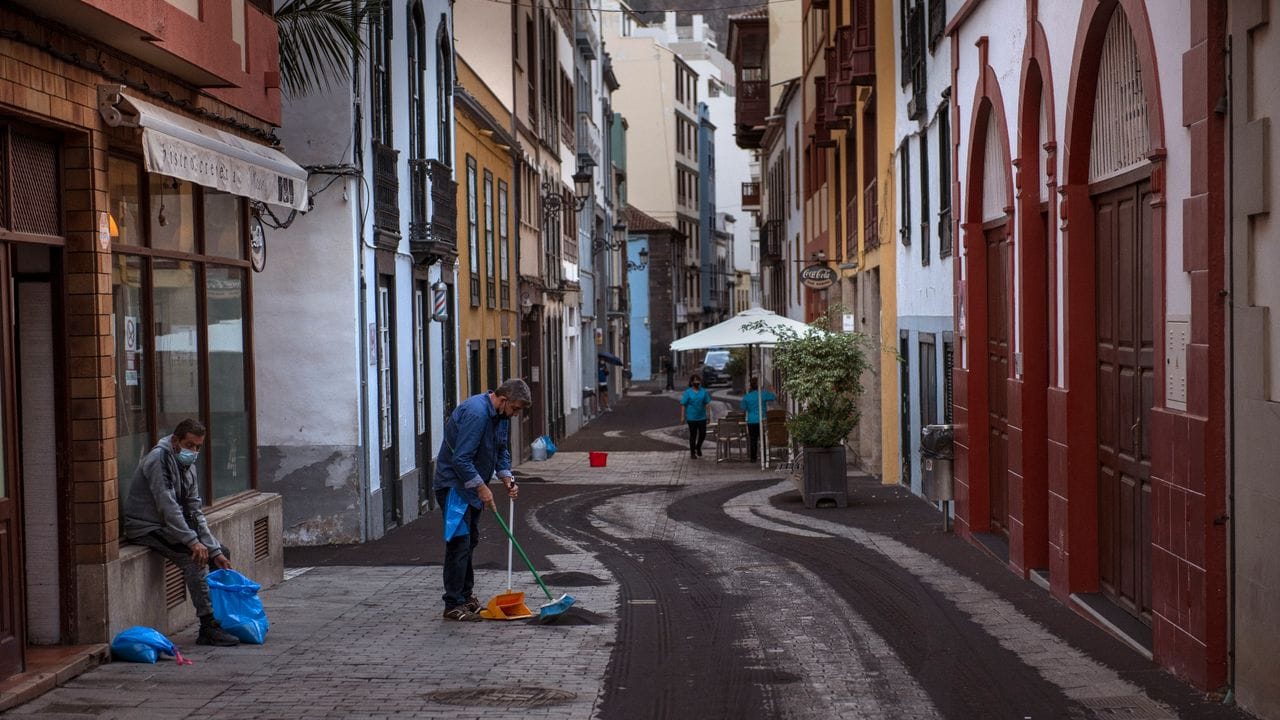 Anwohner säubern die Straße in Santa Cruz de la Palma von Asche.