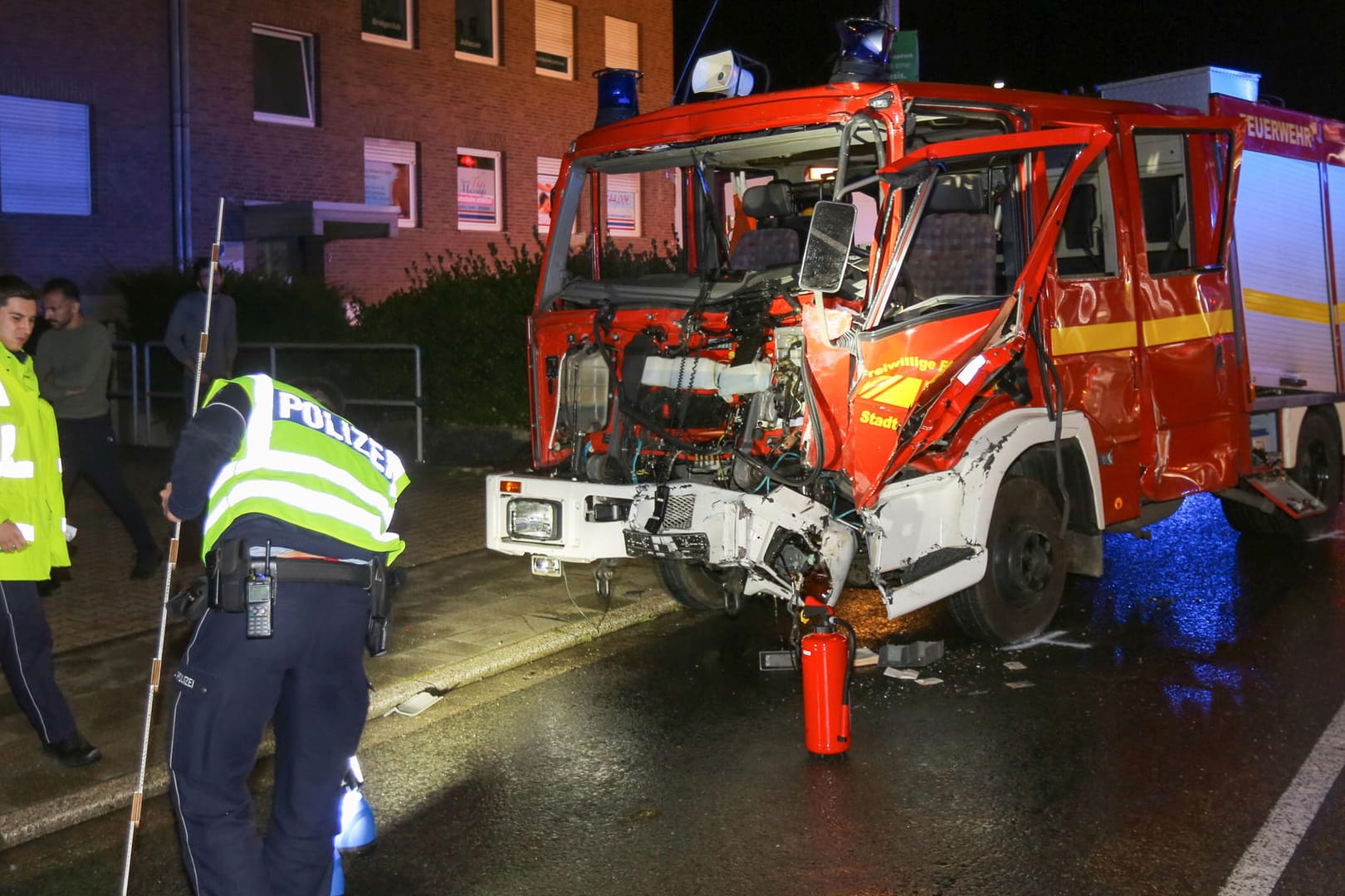 Polizisten sichern vor dem verunfallten Feuerwehrauto Spuren: Neun Menschen, darunter sieben Feuerwehrleute, sind teils schwer verletzt worden.