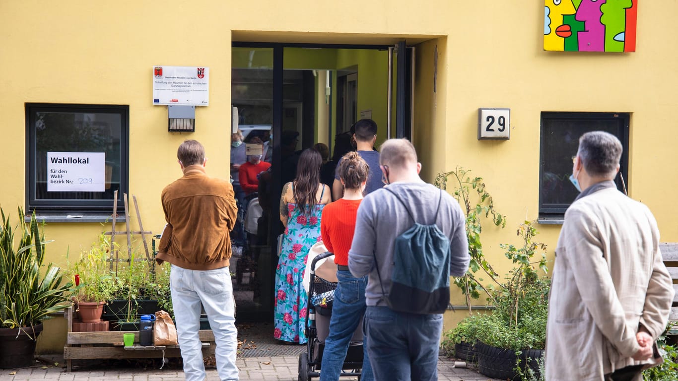 Wahlberechtigte stehen Schlange vor einem Wahllokal in Berlin-Neukölln: In mehreren Bezirken kam es am Sonntag zu chaotischen Szenen.