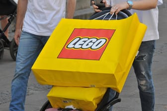 Menschen mit Lego-Einkaufstüten (Symbolbild): Die Bauklötze waren schon während der Pandemie äußerst beliebt, nun konnte das Unternehmen seinen Gewinn verdoppeln.