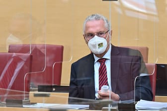 Staatsminister Joachim Herrmann (CSU) in einer Plenarsitzung des Bayerischen Landtags (Archivbild): FFP2-Maske und Plexiglasscheiben bleiben hier Pflicht.