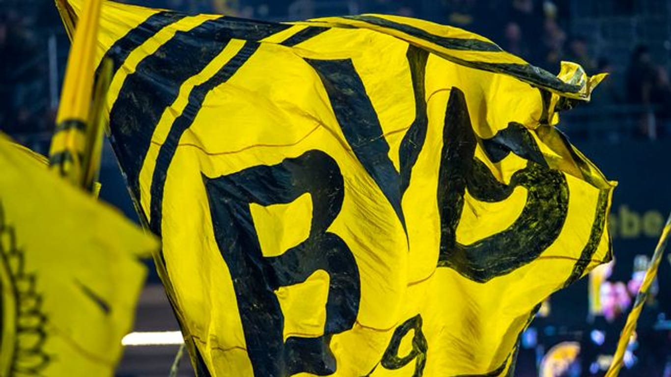 Die Dortmunder Fans auf der Südtribüne schwenken eine BVB-Fahne