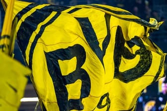 Die Dortmunder Fans auf der Südtribüne schwenken eine BVB-Fahne