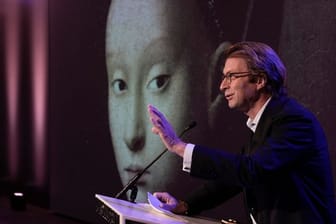 Taco Dibbits, Generaldirektor des Rijksmuseums, spricht über die Ausstellung "Remember Me" (dt: Vergiss mich nicht), während das Porträt einer jungen Frau von Petrus Christus auf die Leinwand projiziert wird.