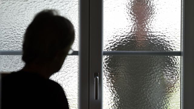 Eine Frau steht an einer Glasscheibe, hinter der die Silhouette eines Mannes zu sehen ist (Symbolbild): In Bayern gelten bald härtere Strafen für Stalker. Eine Frau steht an einer Glasscheibe, hinter der die Silhouette eines Mannes zu sehen ist (Symbolbild): In Bayern gelten bald härtere Strafen für Stalker.