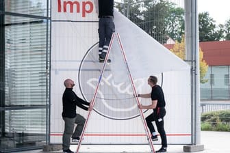 Arbeiter entfernen ein Transparent