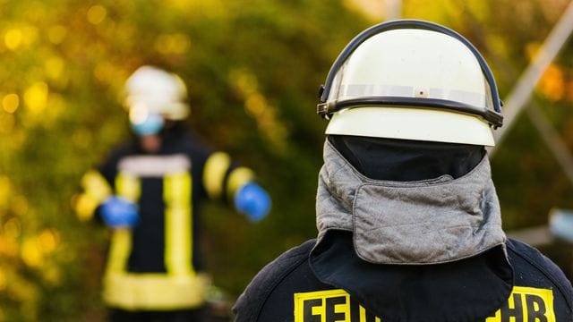 Einsatzkräfte der Feuerwehr stehen auf der Straße