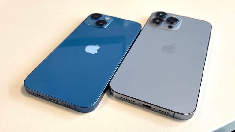 Das iPhone 13 (links) hat eine spiegelnde Glasrückseite und wird von einem matten Aluminiumband umschlossen. Beim iPhone Pro ist es eine mattierte Glasrückseite und ein spiegelndes Edelstahlband.